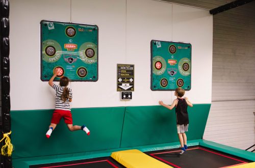 Deux enfants sautant pour toucher des cibles lumineuses sur un mur interactif