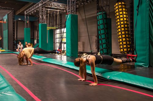 Adolescents réalisant des exercices physiques sur trampoline dans un parcours ninja